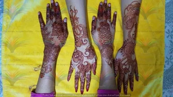 girls hand with mehndi on it