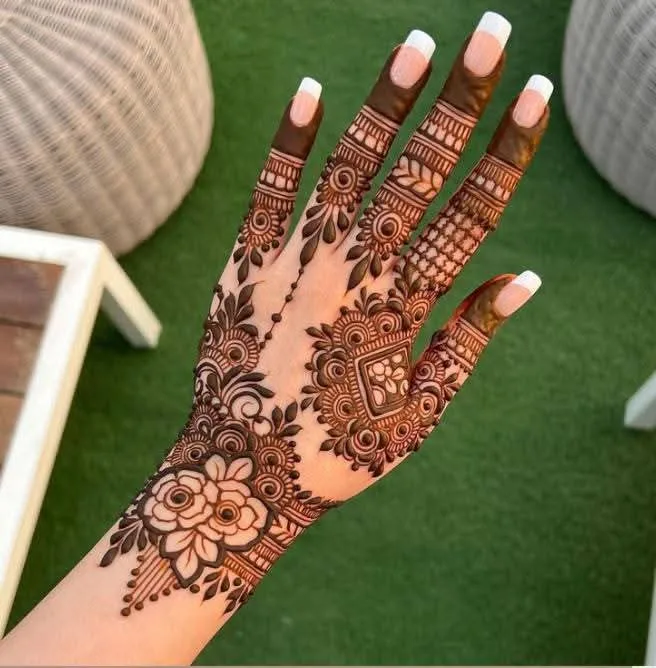 250+ Best Mehndi Designs for Hand Picture and Videos 77 female showing back hand mehndi desings and grass and furniture on background