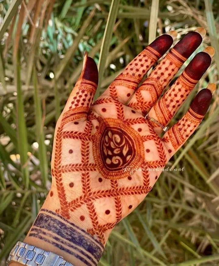 250+ Best Mehndi Designs for Hand Picture and Videos 61 frot side mehndi applied femae showing hand with grass on back side