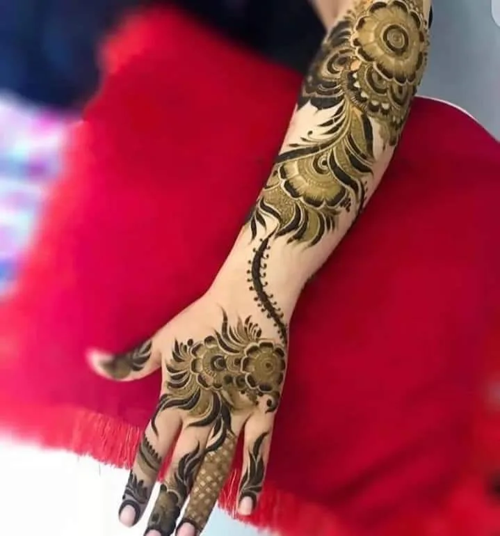 250+ Best Mehndi Designs for Hand Picture and Videos 42 kids back hand mehndi design placing hand on red pillow