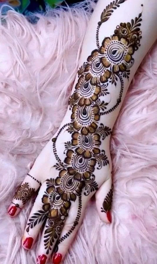 250+ Best Mehndi Designs for Hand Picture and Videos 25 peacock style mehndi on back hand and hand place on pink wool