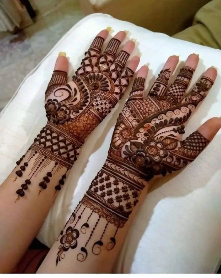 250+ Best Mehndi Designs for Hand Picture and Videos 22 placing both hand on white surface and shoing mehndi design on it