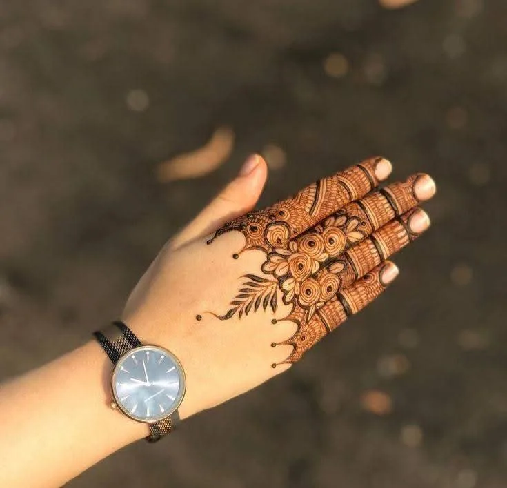50 Best Backhand Mehndi Design Pictures and Videos 2 show off fingers mehndi desing back hand side with wearing watch