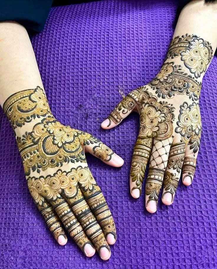 50 Best Backhand Mehndi Design Pictures and Videos 59 showing back hand mehndi design applied on both hand on purple colour surface